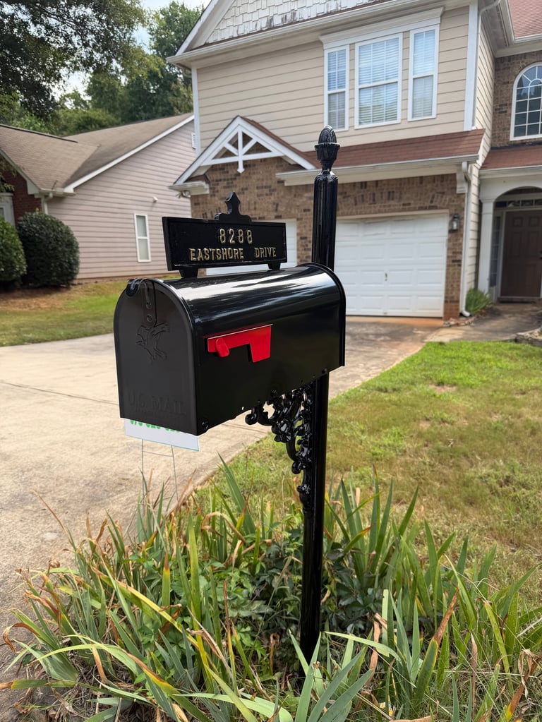 Black mailbox with red flag at the end of a residential driveway, displaying address number 5728 Eastshore Suite